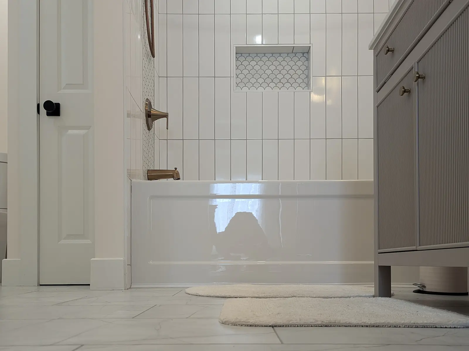 MD-Construction_projects_home-renovations-2_1600 Modern bathroom renovation with white tile and built-in niche completed by MD Construction as part of a home renovations project.